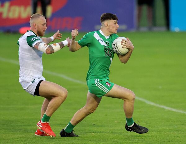 Sarsfields's Ben Loakman holds onto the ball despite the pressure from Moorefield's Ryan Moore