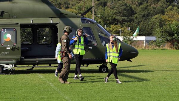 Oisin Monks and Tara McCormack are escorted off the aircraft on the CPC Kilcullen football ground