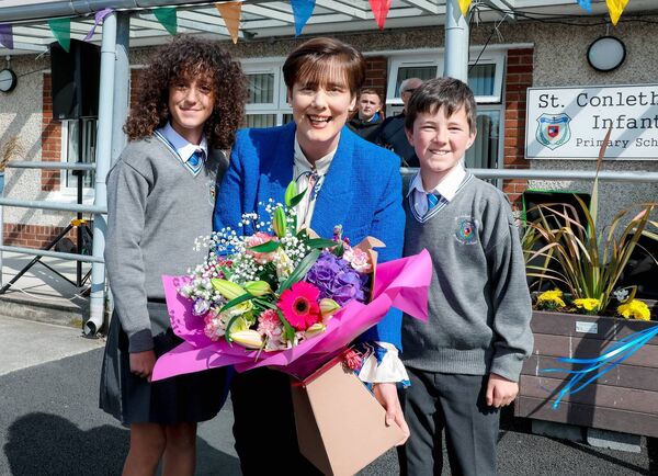 Alea Ferizi and Ben Sheperd present Minister Norma Foley with flowers