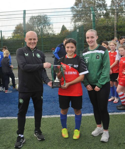 Pat Behan (FAI Develpment Officer, Kildare) and Peamount Utd player Keelin Dermody presents the Division 2 trophy to Gemma Canchal - Zhang (Scoil Eoin Phoil, Leixlip captain) Photo: Martin Rowe