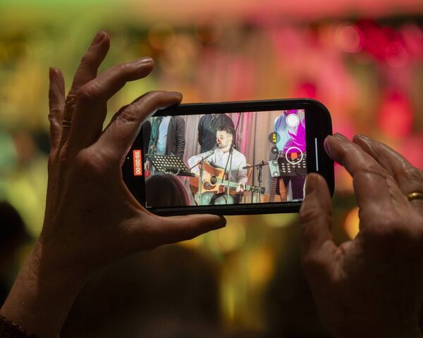 An audience member captures a shot of Joseph Gorman in performance