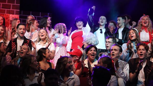 Tara McNally plays Rizzo, girl in red dress in centre in the scene from the show finale Tara McNally plays Rizzo, girl in red dress in centre in the scene from the show finale