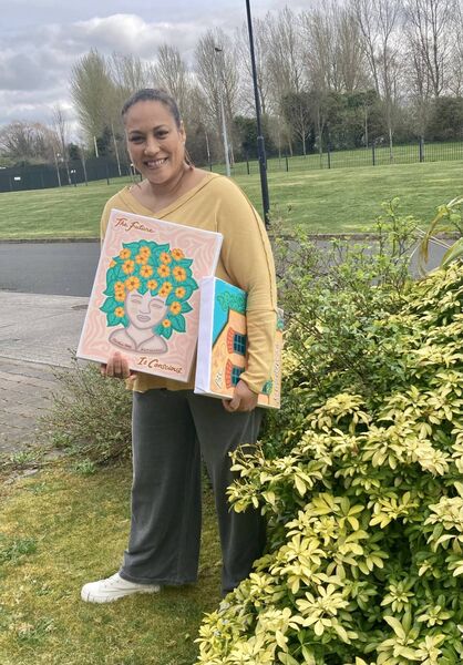 Charlene Potts standing with some of her paintings