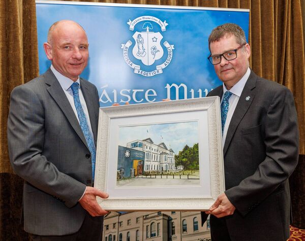 Michael Regan chairperson of the Board of Management on behalf of the board presents Michael with a painting of the college Michael Regan chairperson of the Board of Management on behalf of the board presents Michael with a painting of the college