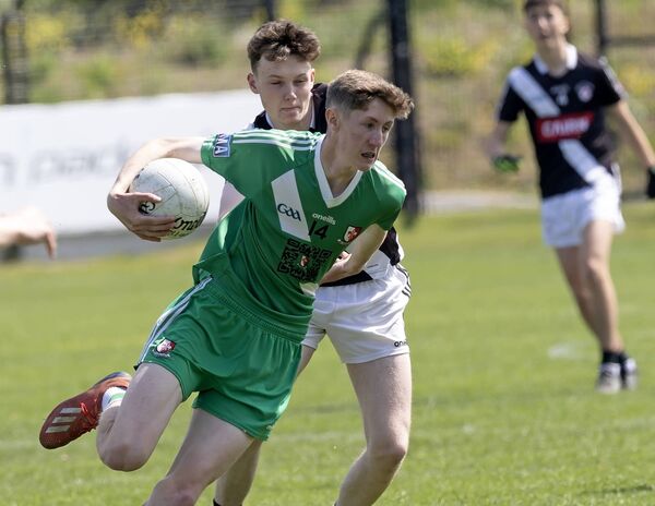 Sarsfields's Tadhg Murphy is tackled by Maynooth' Conall Knox