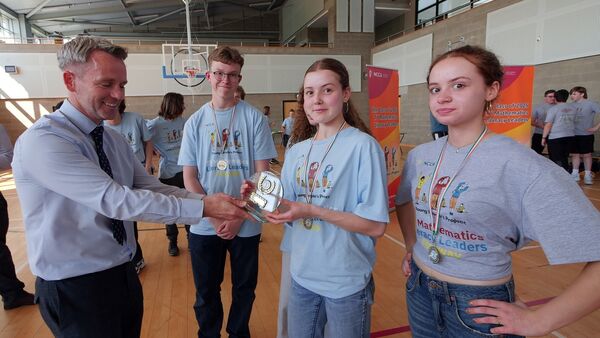 The Principal of KTCS John Hayes presenting the trophy to the runners-up from Cork Educate Together Secondary school