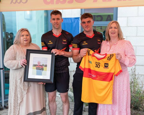 St Laurences Club captains Niall Clinch and Niall O'Connor make presentations to Aine Walsh and Roisin Walsh