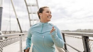 <p>Overweight young woman running on bridge</p>