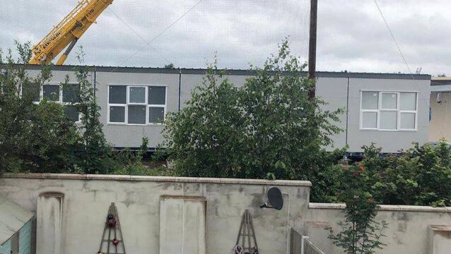School prefab is overlooking local homes