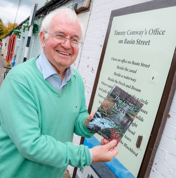Timmy Conway stands on Basin Street Naas with a copy of his new book 'The Jewel of Naas'