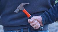 Two men threaten woman with hammers