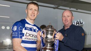 <p>Naas captain Brian Byrne receives the Tony Carew Cup from Tom Carew Photo: Sean Brilly</p>