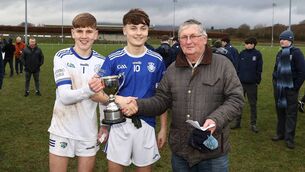 <p>Rory Kinsella representing Leinster Schools GAA presents the South Leinster 'A' football trophy to Knockbeg joint captains Mark Dowling and Conor Murphy.</p>