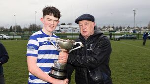 <p>Knockbeg captain Evan Brennan is presented with the Leinster 2nd year 'A' football cup by Con Ronan, representing Leinster Schools. Photo: Pat Ahern </p>