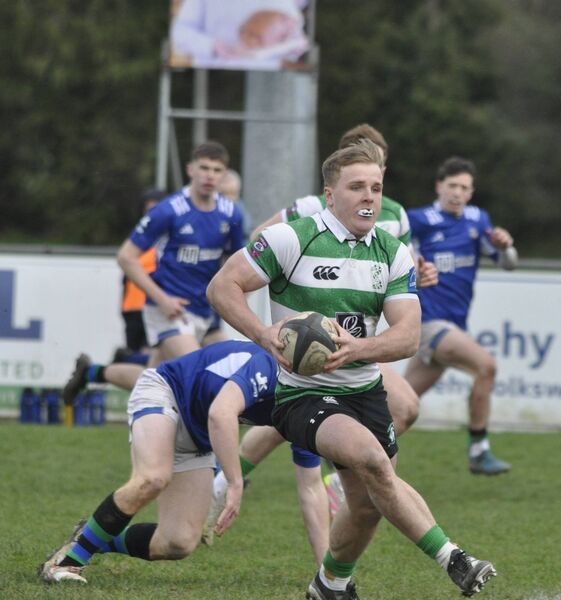Naas's Charlie Sheridan spins around Joe Hopes of Queens with the ball in two hands. Naas's Charlie Sheridan spins around Joe Hopes of Queens with the ball in two hands.