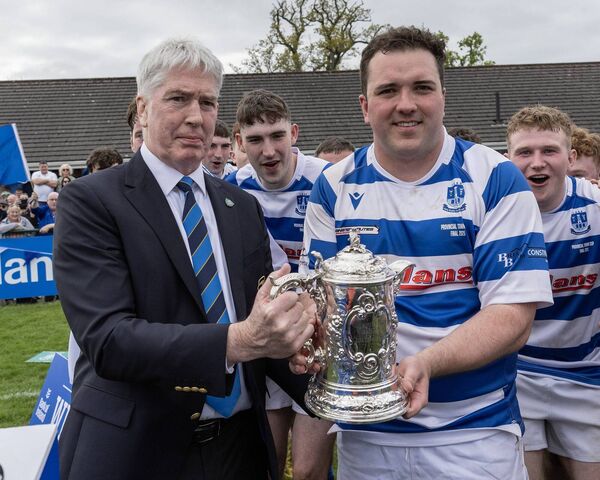 Leinster President Declan Gardiner presenting the Bank of Ireland Provincial Town's cup to Athy's captain Tadgh Foley.