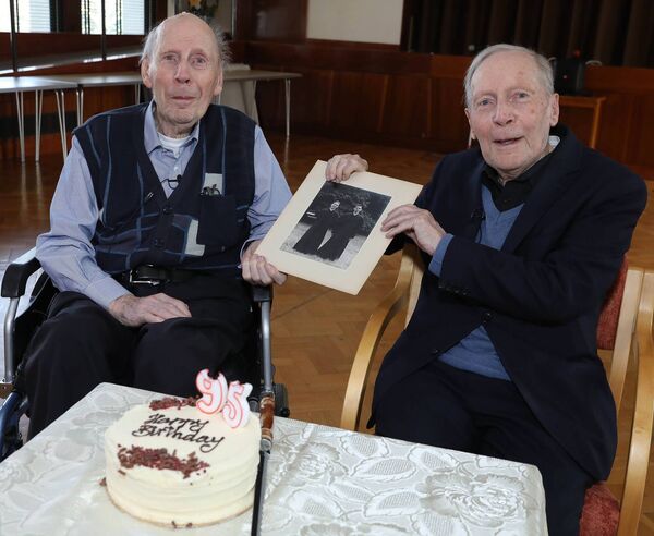 Fathers Joe and Matt Kelly with a picture from their early days in the priesthood