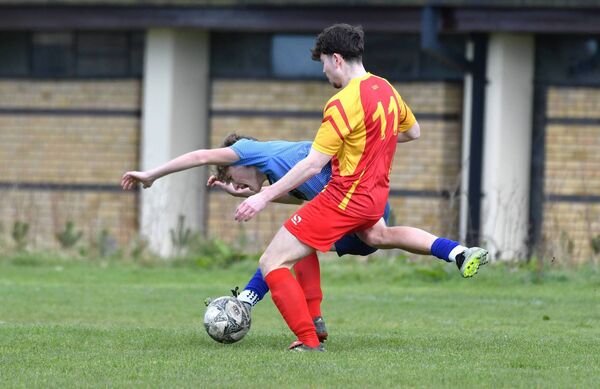 Rathangan goalscorer Timas Kacinskas goes over from the tackle of John Anderson (Ballycane Celtic).