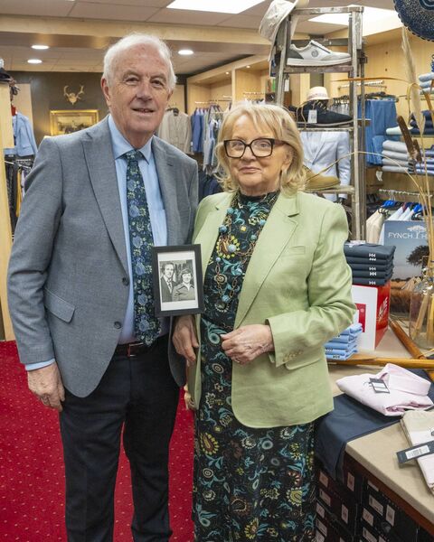 Tom and Susan with a picture of themselves many years ago in the shop. 