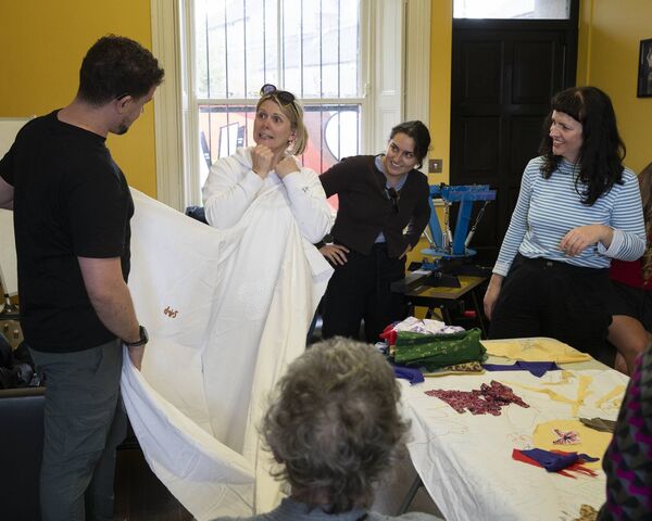 Jason Maguire, Maggie Owens, Laila Anshasi and Cathy Heffernan communicating through sign discussing their banner