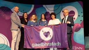 <p>Students from Gaelcholáiste Chill Dara, are presented with their Gaelbhratach (Irish flag) at Mary Immaculate College this week. Photo: Eamon Ward.</p>