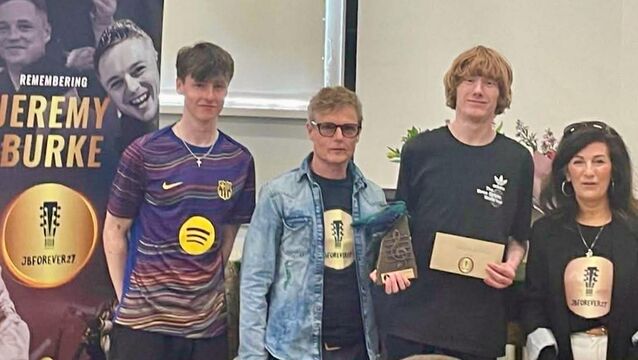 <p>Carl Kenna, second from right, receiving his bursary from Jeremy's parents Gerry and Louise, with Jeremy's brother William on the left</p>