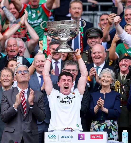 Mayo captain Jack Coyne lifts the Sam Maguire Cup as President Connolly watches on. 	Photo: INPHO/Tom O’Hanlon