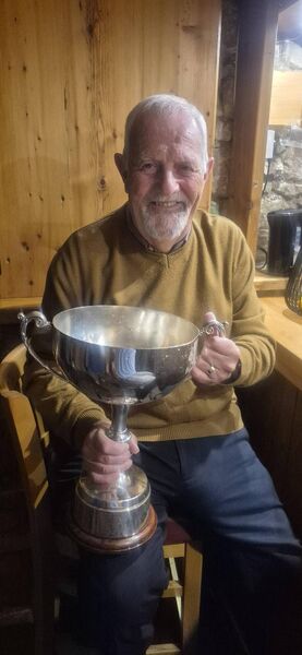 Castle Villa legend, Ollie Coleman with a big smile on his face as he holds the Division 2 trophy.