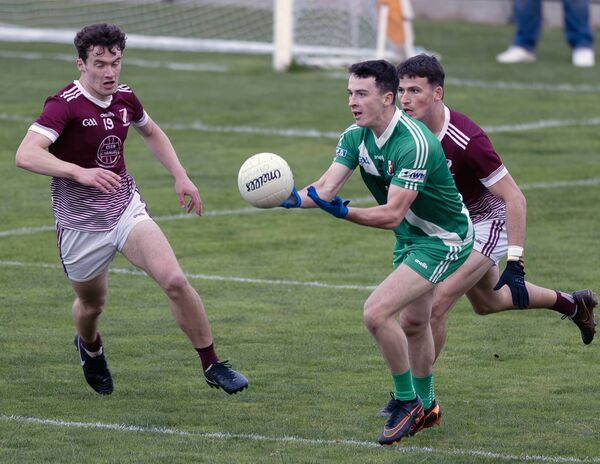 Sarsfields' Daragh Conlon moves the ball away from Caragh's Darragh Swords and Mick O'Toole. Sarsfields' Daragh Conlon moves the ball away from Caragh's Darragh Swords and Mick O'Toole.