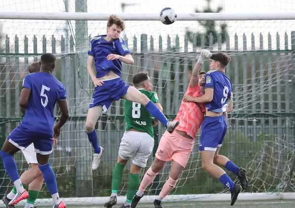Newbridge Town's Seamus Brown heads clear from this Villa corner kick. Photos: Noel Browne