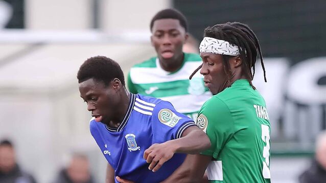 <p>Newbridge Town's Moses Alabi holds off the challenge from Villa's John Tamen </p>